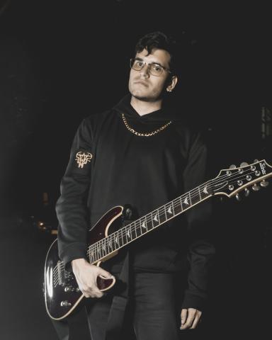 Jonny, Guitarrista de Ground of Chaos Foto de guitarrista de la banda ground of chaos sostienendo una guitarra en la noche con ropa negra